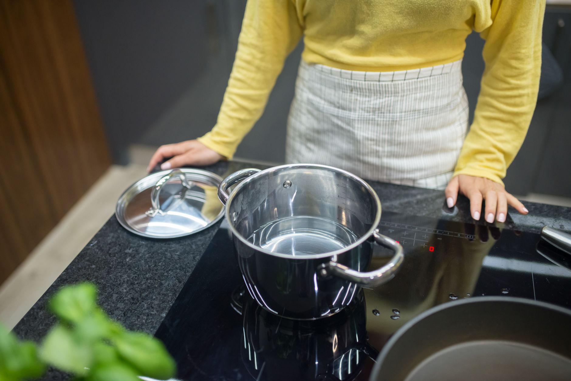 A set of stainless steel pots and pans on a kitchen counter