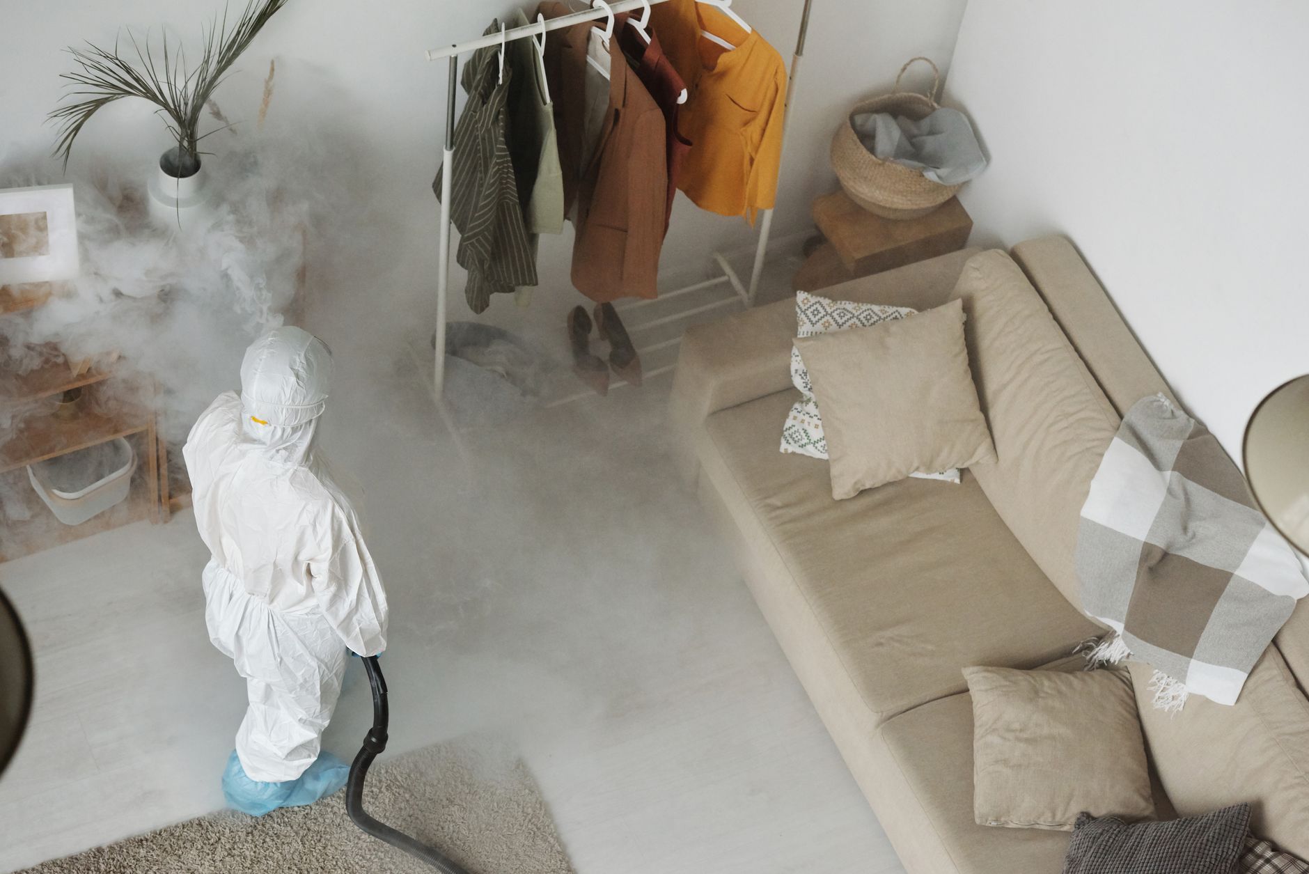 a person spraying a bottle of pest spray along a kitchen baseboard