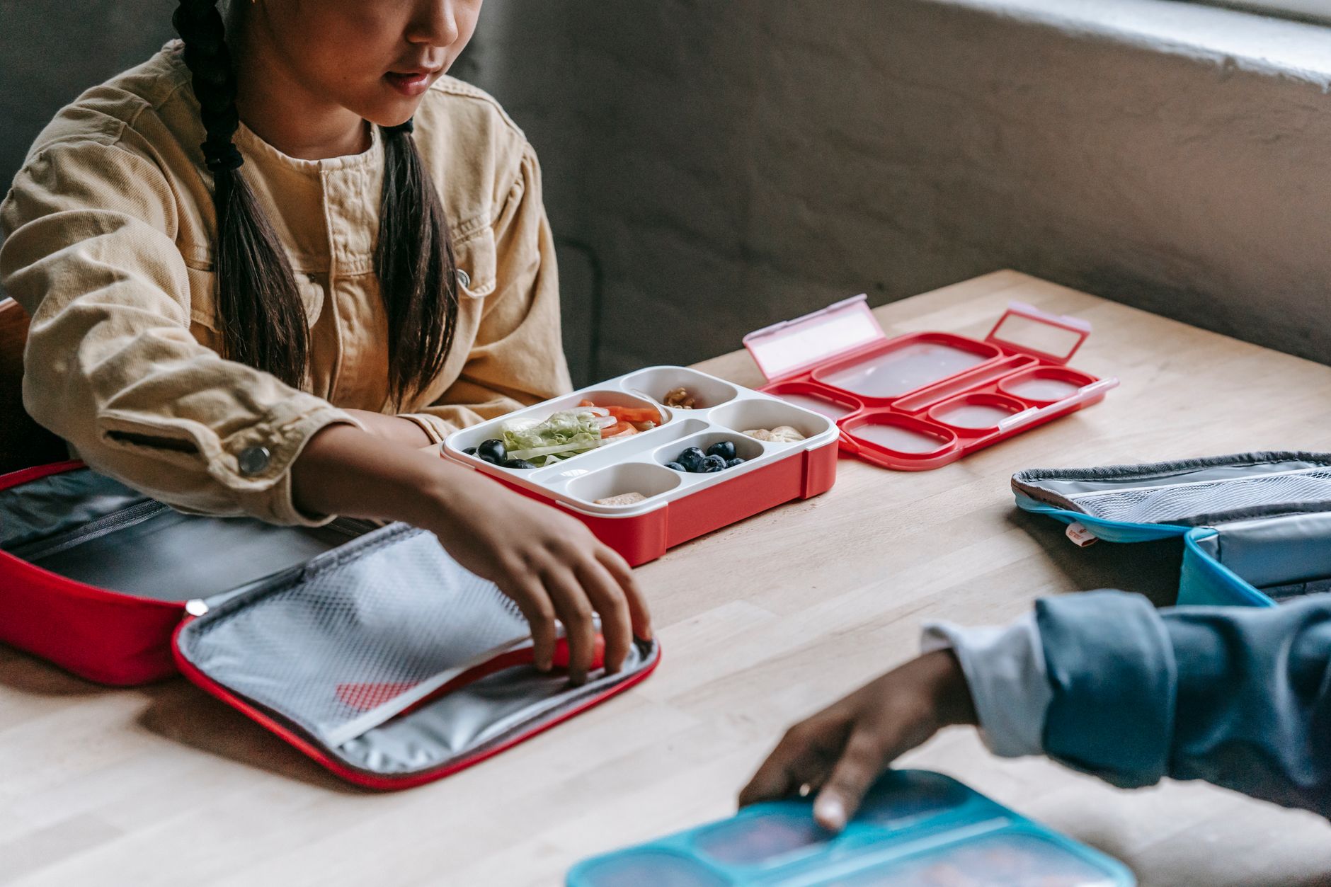 Meal prep glass containers with three compartments on a wooden table